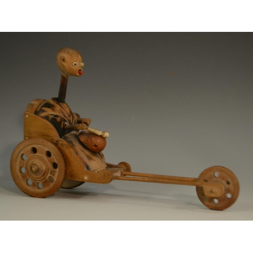 3104 - A Japanese Kobe automaton toy, as a comical figure in a carriage, the wheels animating his limbs, 20... 