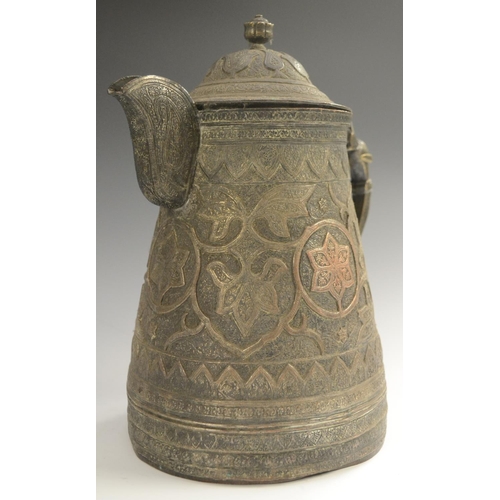 3108 - A Kashmiri copper flagon, profusely chased in the Persian taste with stylised lotus, flowering meand... 