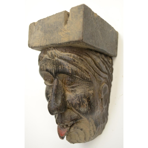 3138 - A post-Medieval oak corbel grotesque, carved as a bearded man, his tongue protruding, 14cm long; ano... 