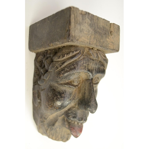 3138 - A post-Medieval oak corbel grotesque, carved as a bearded man, his tongue protruding, 14cm long; ano... 