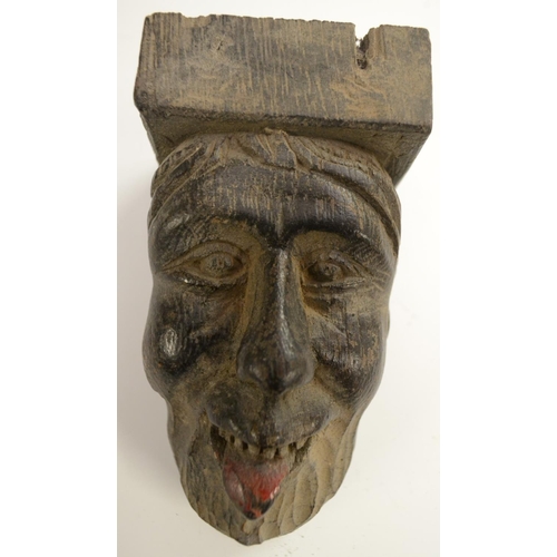 3138 - A post-Medieval oak corbel grotesque, carved as a bearded man, his tongue protruding, 14cm long; ano... 