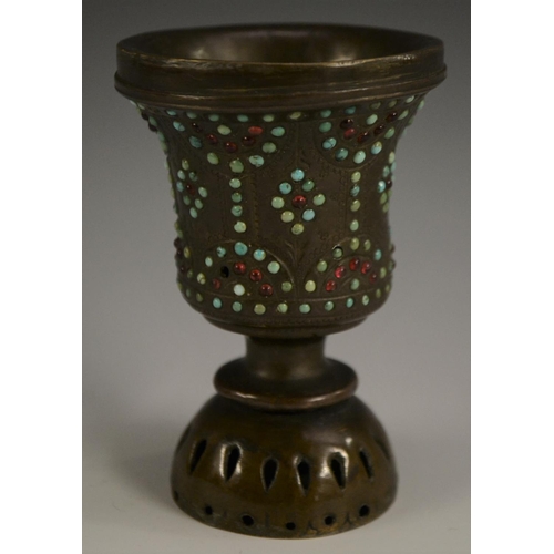 3149 - A Tibetan bronze chalice, chased with strapwork and applied with cabochons, 10cm high