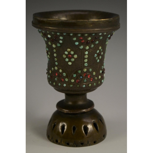 3149 - A Tibetan bronze chalice, chased with strapwork and applied with cabochons, 10cm high