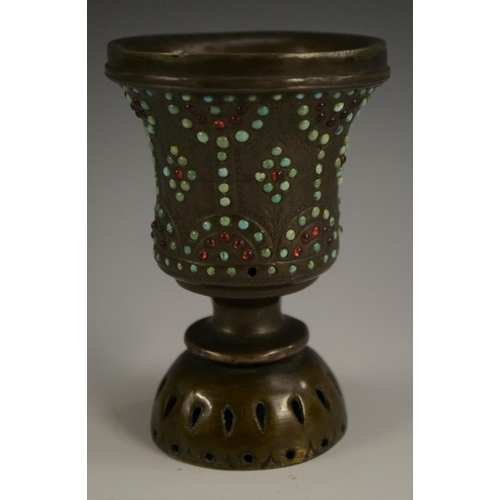 3149 - A Tibetan bronze chalice, chased with strapwork and applied with cabochons, 10cm high