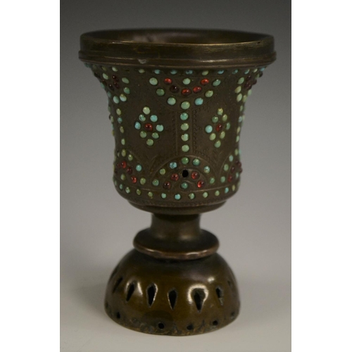 3149 - A Tibetan bronze chalice, chased with strapwork and applied with cabochons, 10cm high