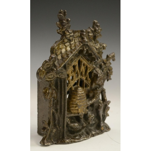 3152 - A Victorian cast iron novelty money box, as a bear raiding a bee skep, 14cm high, c. 1885