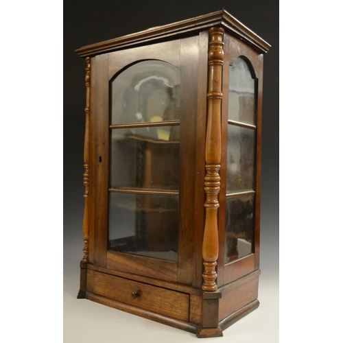 3158 - A Victorian walnut table top display cabinet, serpentine caddy top above an arched glazed door flank... 