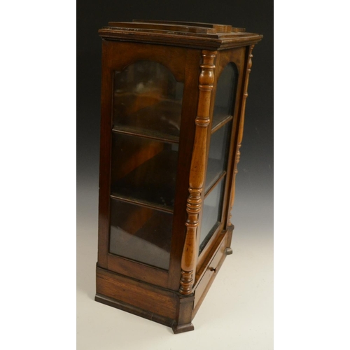 3158 - A Victorian walnut table top display cabinet, serpentine caddy top above an arched glazed door flank... 