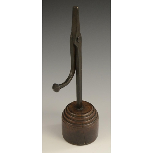 3162 - A wrought iron nip rushlight holder, stepped circular hardwood base, 27.5cm high