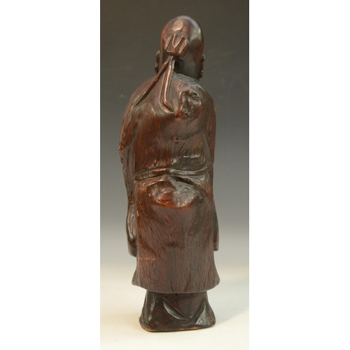 3073 - A Chinese rootwood figure, of a bearded immortal, he stands, wearing long robes, 32cm high, 19th cen... 