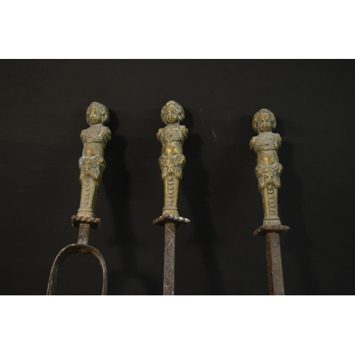 3143 - A set of three Baroque steel and brass fire irons, comprising tongs, shovel and poker, each terminal... 