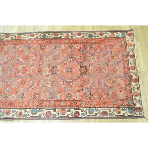 3121 - A Middle Eastern rectangular woollen carpet, the runner with a field of stylised flowers within guar... 