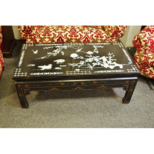 329 - A Japanned coffee table inlaid with Abalone flora and fauna. 45cm high x 60.5cm wide x 120cm long.
