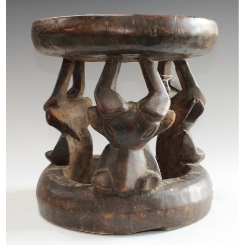 5134 - Tribal Art - a West African hardwood stool, possibly Kwele, Gabon, dished circular top, stylised ant... 