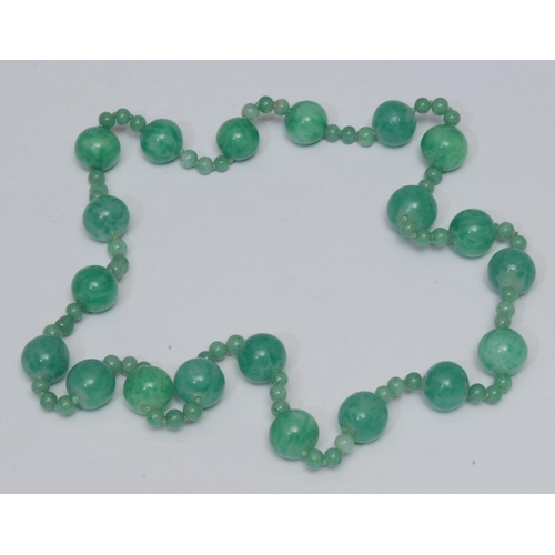 1019 - A green glass jade effect bead necklace, large irregular globular beads each divided by a trilogy of... 