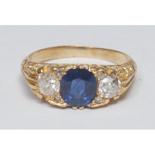 1022 - A sapphire and diamond ring, central oval mid blue sapphire, approx 1.31ct, flanked by an old brilli... 