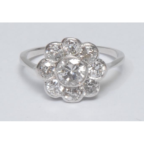 1024 - A diamond floral cluster ring, central round brilliant cut diamond surrounded by a collar of eight s... 