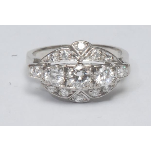 1029 - An Art Deco style diamond cluster ring, multilevel platform inset with three larger central round br... 