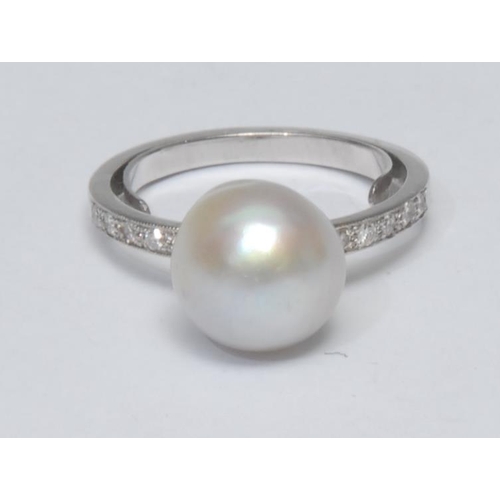 1031 - A pearl and diamond ring, large creamy silver white cultured pearl, approx 11mm diameter, above ten ... 