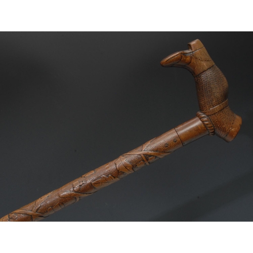 1188 - A late 19th/early 20th century century Folk Art walking stick, the handle carved as a leg wearing a ... 