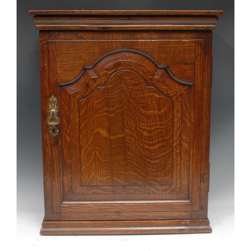 1254 - A '19th century' oak spice cupboard, moulded cornice above a shaped arched raised and fielded panel ... 