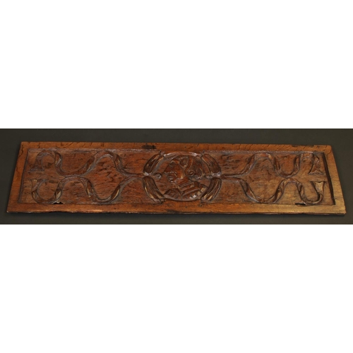 1284 - A 16th/17th century oak rectangular panel, carved with a portrait roundel, 106.5cm wide