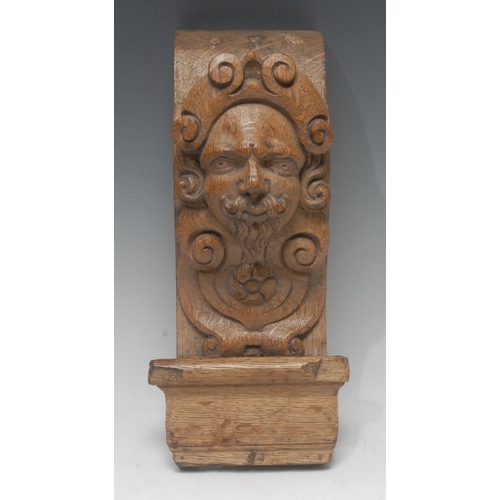 1387 - A 19th century oak figural bracket, carved with the head of a bearded gentleman, 29cm long