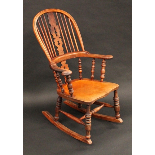 1407 - A 19th century yew and elm Windsor rocking chair, hoop back, shaped and pierced 'Christmas tree' spl... 