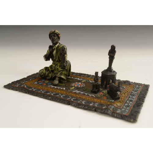 1560 - Austrian School (20th century), a cold-painted bronze, of a carpet seller, seated he proffers Egypti... 