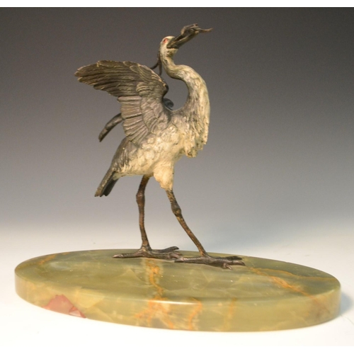 1597 - A late 19th century cold painted stork, a fish in its beak, onyx oval base, 23cm high