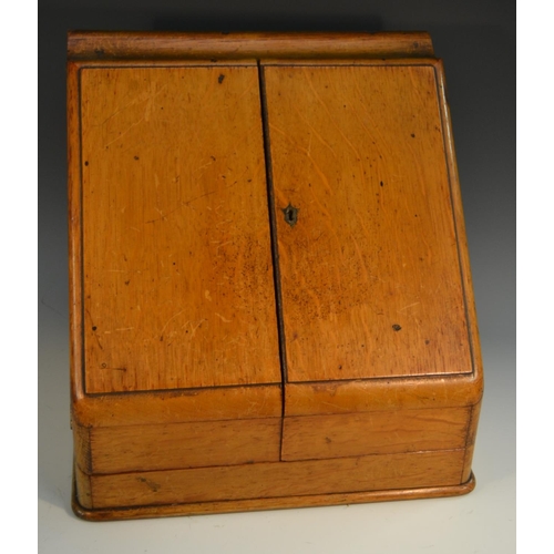 1606 - A late Victorian oak slope front desk top writing cabinet, hinged twin-covers enclosing perpetual ca... 