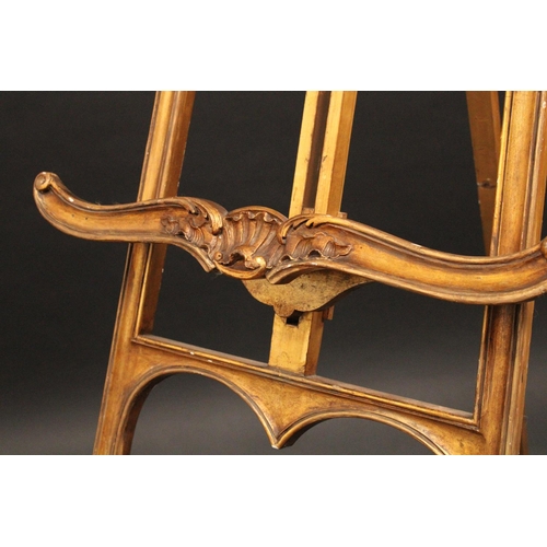 1613 - A Louis XV Revival giltwood gallery easel, carved throughout with scrolls and acanthus, outswept leg... 