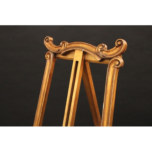 1613 - A Louis XV Revival giltwood gallery easel, carved throughout with scrolls and acanthus, outswept leg... 