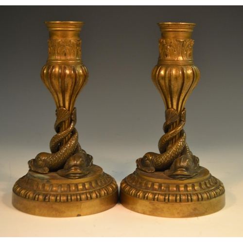 1652 - A pair of 19th century bronze candlesticks, each cast with three dolphins, acanthus-grasped sconces,... 