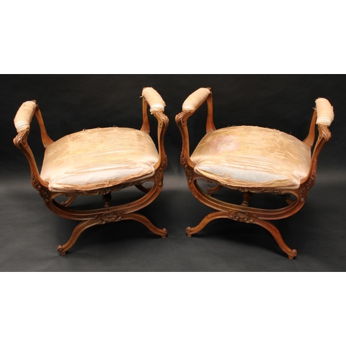 1659 - A pair of 19th century walnut X-frame window seats, manchette sides, stuffed over seats, the frames ... 