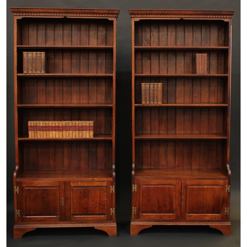 1680 - A pair of oak library bookcases, each with dentil cornice above four shelves, the projecting bases w... 