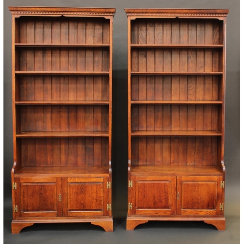 1680 - A pair of oak library bookcases, each with dentil cornice above four shelves, the projecting bases w... 