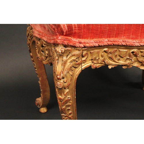 1713 - A Rococo giltwood serpentine stool, stuffed over seat, the deep frieze and cabriole legs pierced and... 