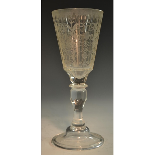 190 - A 19th century  Bohemian wine glass, etched and engraved with masks, leafy scrolls and foliage, cup-... 