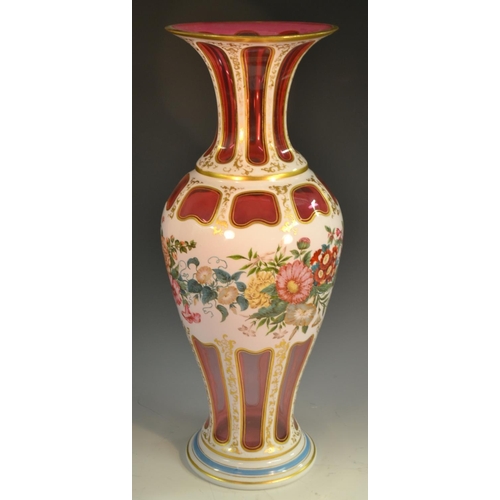 205 - A large Bohemian ruby overlaid baluster  vase, painted with flowers and foliage, picked out with gil... 