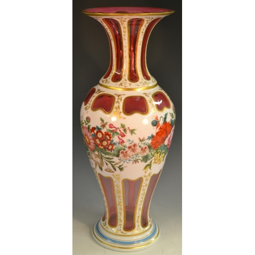 205 - A large Bohemian ruby overlaid baluster  vase, painted with flowers and foliage, picked out with gil... 