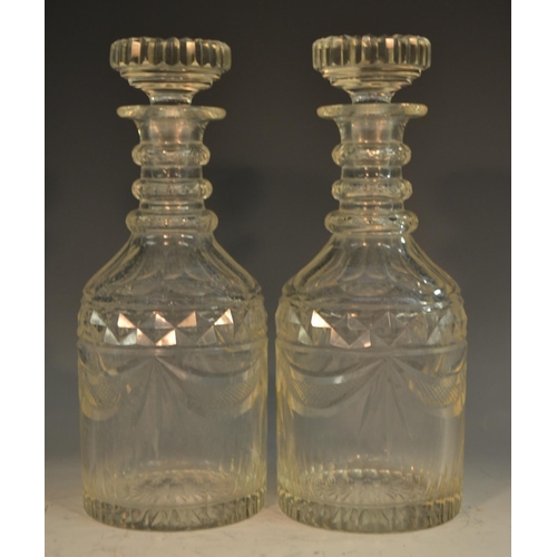 216 - A pair of post-Regency mallet-shaped cut glass decanters, each reservoir with a singular hobnail ban... 