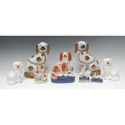 24 - A pair of Staffordshire dogs, seated to the left and right, front legs free,  copper lustre markings... 