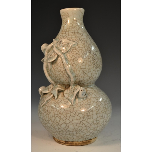 289 - A Chinese crackle glaze celadon double gourd vase, moulded and applied with peach blossom, 21cm high