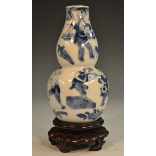 291 - A Chinese double gourd vase, painted in tones of underglaze blue with the Hundred Boys, 13.5cm high,... 