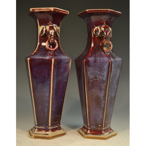 320 - A pair of Chinese stoneware hexagonal panelled vases, glazed in merging tones of red and purple, ele... 