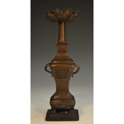 340 - A Chinese bronze candlestick, lotus sconce, vase shaped pillar with scroll handles and cast with pan... 