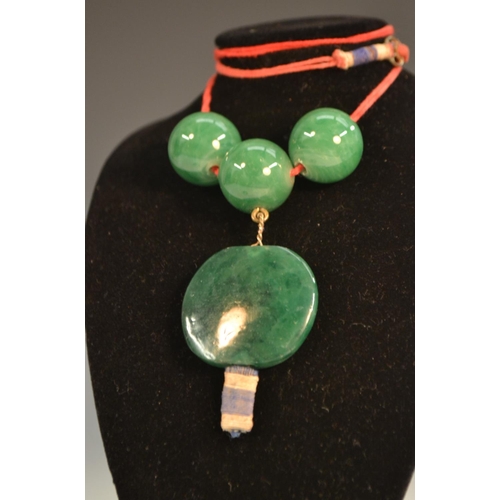 359 - A string of thirty-six graduating Chinese green jade beads, the largest with a suspended droplet, 28... 