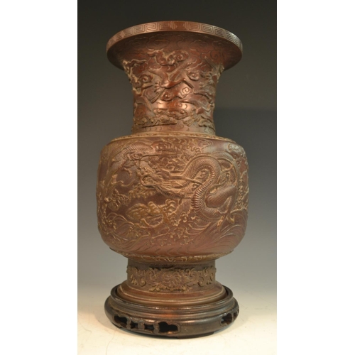 370 - A Chinese brown-patinated bronze baluster vase, cast in relief with ferocious dragons and scroll clo... 