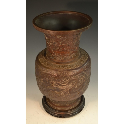 370 - A Chinese brown-patinated bronze baluster vase, cast in relief with ferocious dragons and scroll clo... 